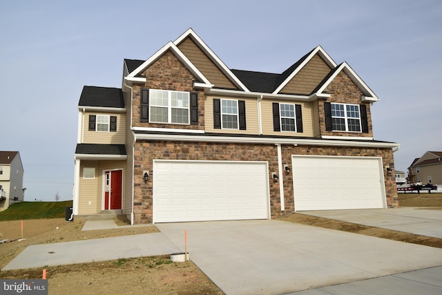 view of front facade featuring concrete driveway, an attached garage, and stone siding