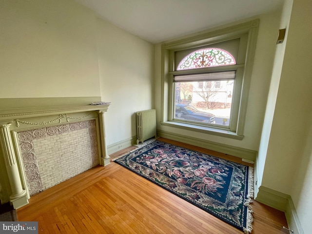 unfurnished living room featuring light wood-type flooring and radiator heating unit