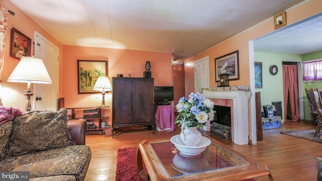 living area featuring a brick fireplace and wood finished floors