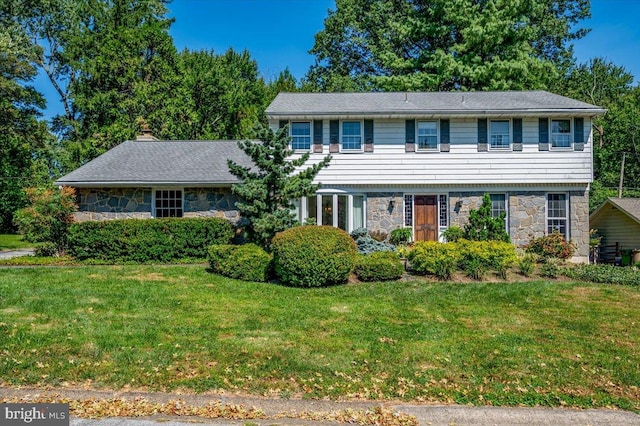 colonial inspired home featuring a front lawn