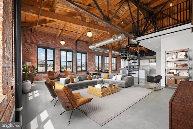 living area with stairway, high vaulted ceiling, concrete flooring, and brick wall