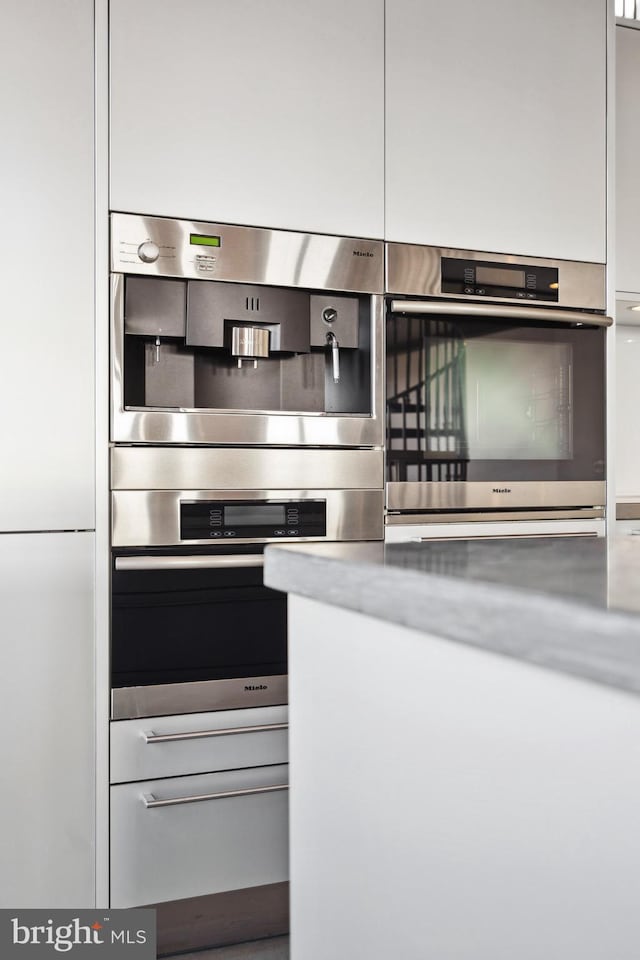 kitchen featuring double oven and white cabinetry