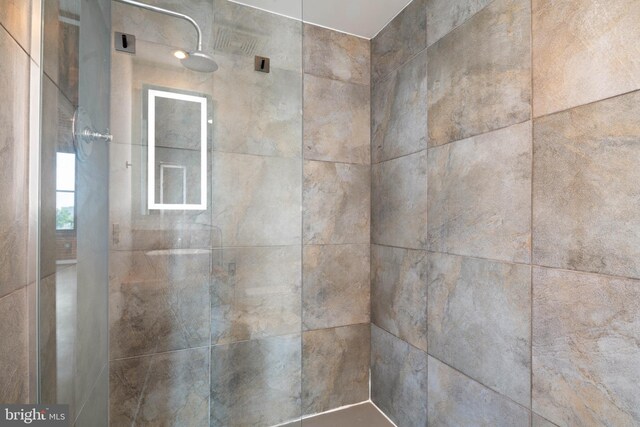 interior details featuring tiled shower