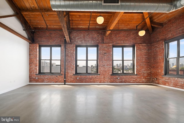 spare room featuring concrete flooring, brick wall, beam ceiling, and wood ceiling