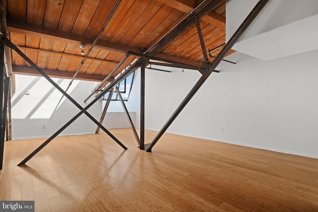 interior space featuring light wood-type flooring, beamed ceiling, and wooden ceiling