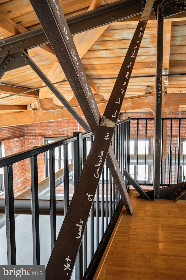 hallway featuring beamed ceiling and hardwood / wood-style floors