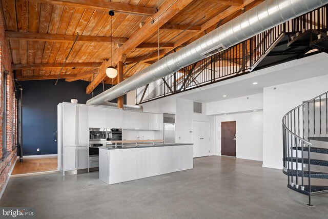 kitchen featuring wood ceiling, beamed ceiling, high vaulted ceiling, and white cabinetry