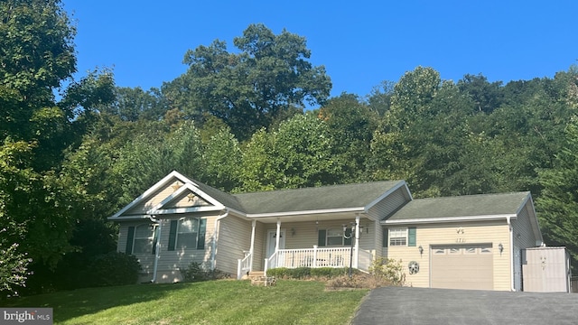 view of front of home featuring a front lawn, a garage, and covered porch