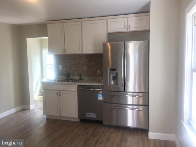 kitchen with a sink, backsplash, stainless steel fridge with ice dispenser, dishwasher, and dark wood-style flooring