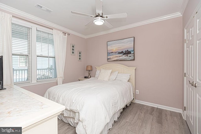 bedroom with crown molding, light hardwood / wood-style flooring, and ceiling fan