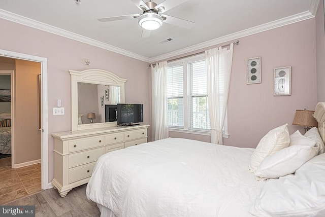 bedroom featuring crown molding, light wood-type flooring, and ceiling fan