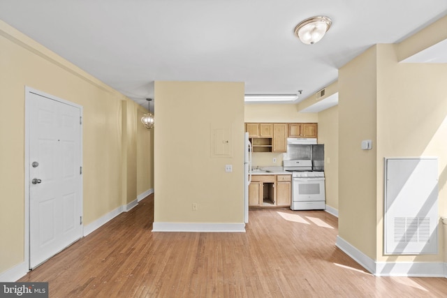 kitchen with light brown cabinetry, light hardwood / wood-style floors, hanging light fixtures, white gas range oven, and sink