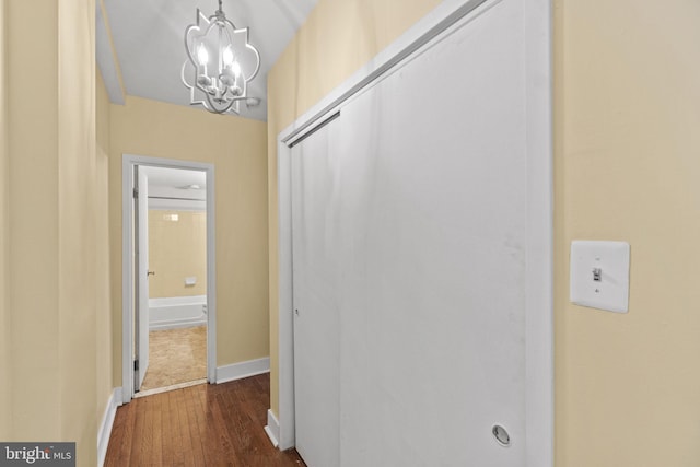 corridor featuring dark hardwood / wood-style floors and a chandelier