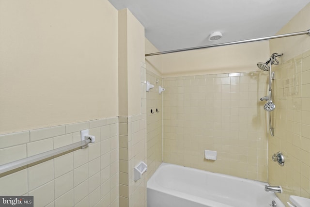 bathroom featuring tiled shower / bath and tile walls