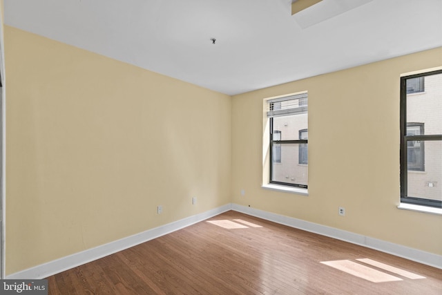 unfurnished room with hardwood / wood-style flooring