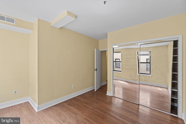 unfurnished bedroom featuring hardwood / wood-style floors and a closet