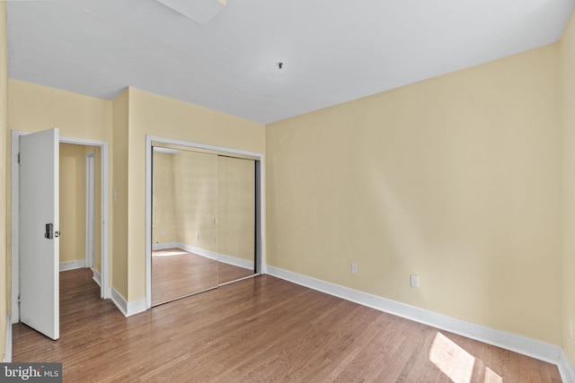 unfurnished bedroom featuring a closet and hardwood / wood-style floors