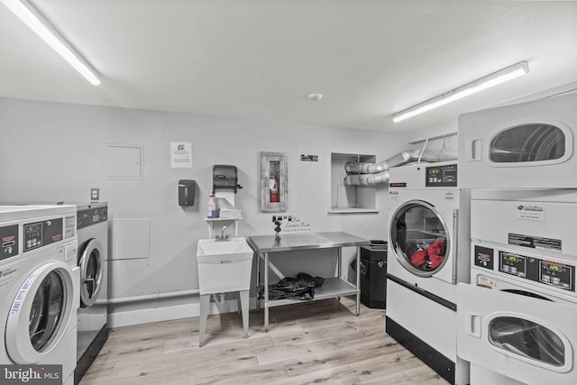 washroom featuring light hardwood / wood-style floors, washing machine and dryer, and stacked washing maching and dryer