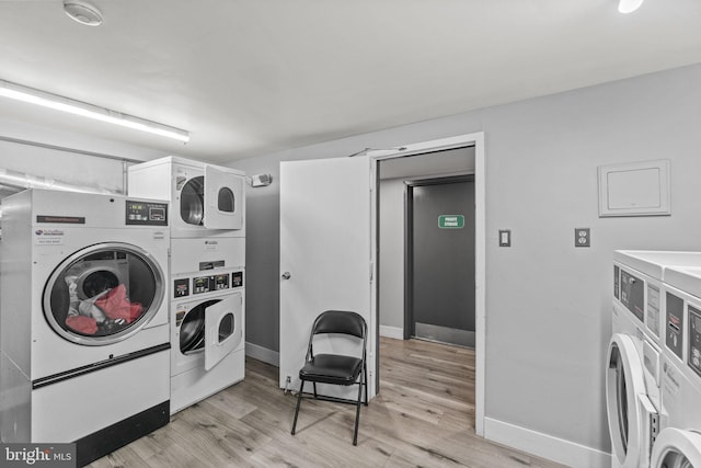 laundry area with light wood-type flooring, washing machine and clothes dryer, and stacked washer / drying machine