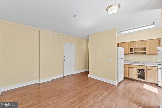 kitchen featuring white appliances, sink, and light hardwood / wood-style floors