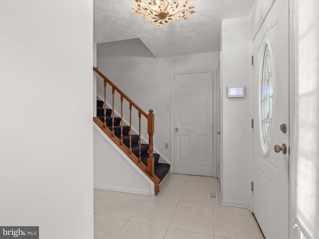 tiled entrance foyer featuring a textured ceiling