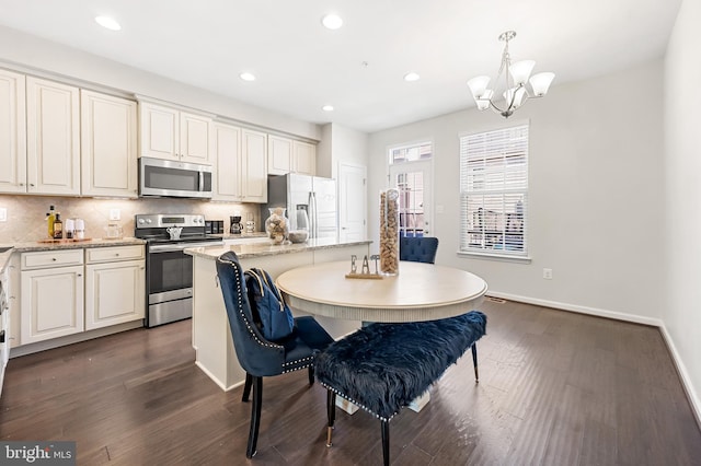 kitchen with backsplash, appliances with stainless steel finishes, a center island, and dark wood-type flooring