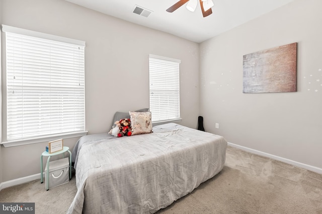 bedroom with visible vents, light carpet, baseboards, and a ceiling fan