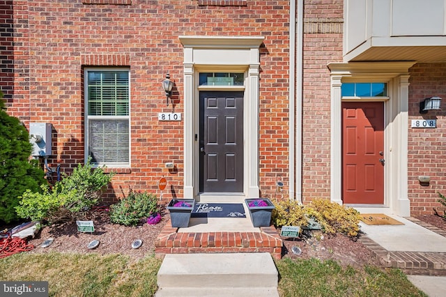 doorway to property with brick siding