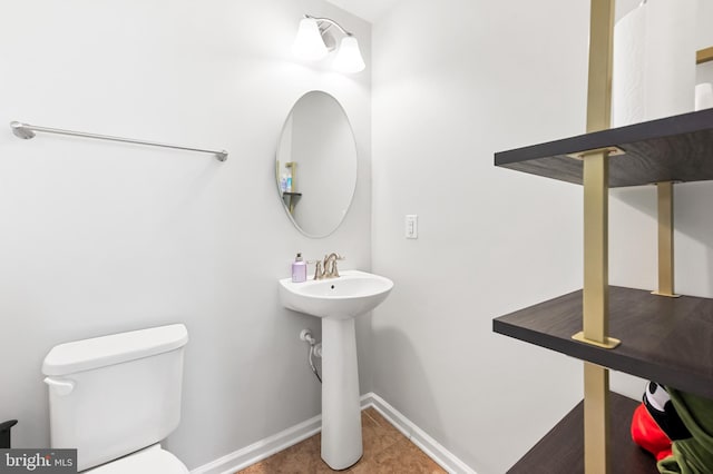 bathroom featuring tile patterned floors, toilet, and baseboards