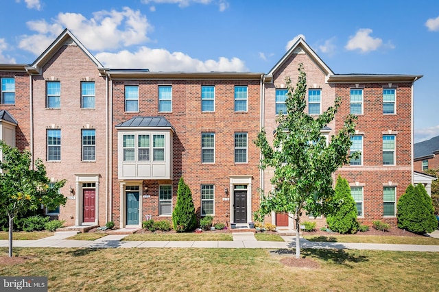 multi unit property featuring brick siding and a front lawn