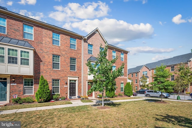 multi unit property featuring brick siding and a front lawn