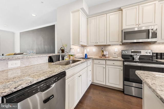 kitchen featuring a sink, backsplash, appliances with stainless steel finishes, and crown molding