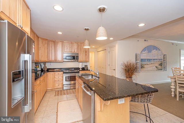 kitchen featuring a kitchen breakfast bar, decorative light fixtures, appliances with stainless steel finishes, sink, and light colored carpet