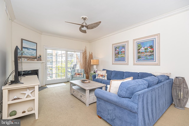 carpeted living room featuring ceiling fan, ornamental molding, and a fireplace