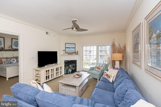 carpeted living area with visible vents, crown molding, and ceiling fan