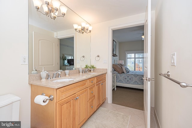 ensuite bathroom with a sink, connected bathroom, double vanity, and tile patterned flooring