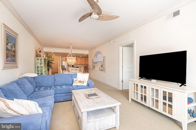 living room with crown molding, ceiling fan, and light colored carpet