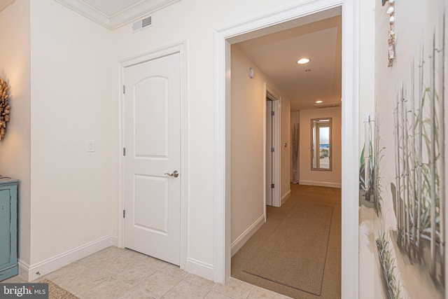 hall featuring crown molding and light tile patterned floors