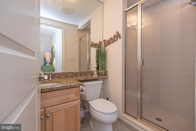 bathroom with tile patterned flooring, a stall shower, toilet, and vanity