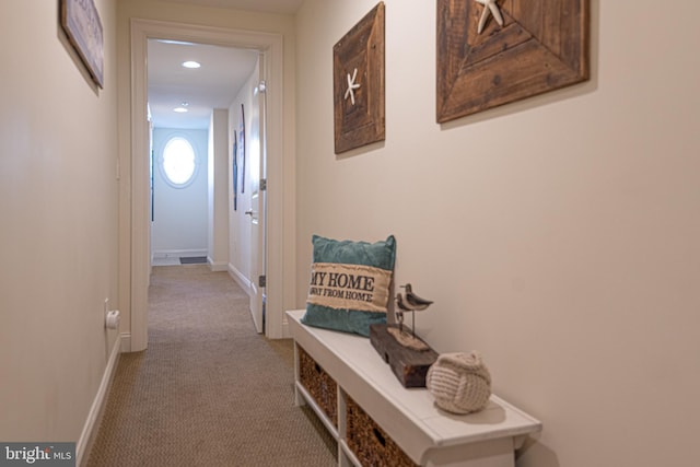 hallway featuring baseboards and carpet