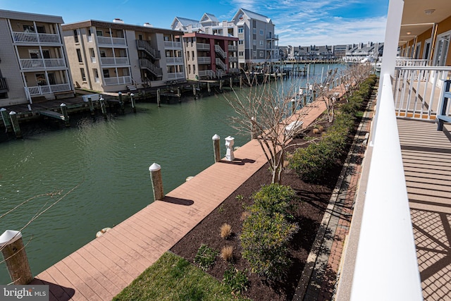 view of dock with a balcony and a water view