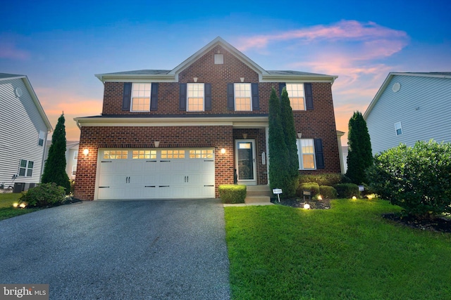 front facade featuring a garage and a yard