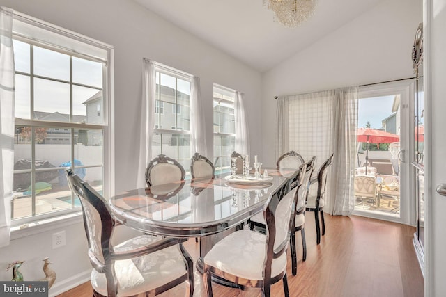 dining space with hardwood / wood-style flooring and lofted ceiling