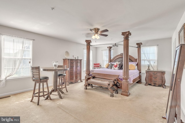 bedroom featuring multiple windows, light colored carpet, and ceiling fan