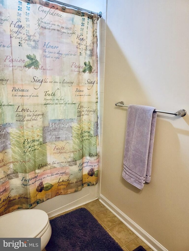 bathroom with toilet, shower / bath combo with shower curtain, and tile patterned floors