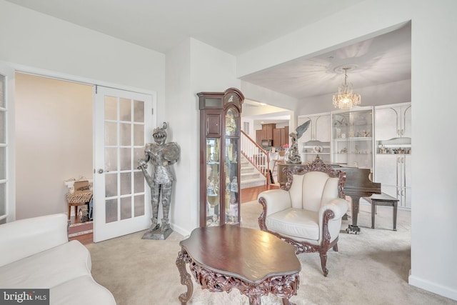 living room with a notable chandelier, light colored carpet, and french doors