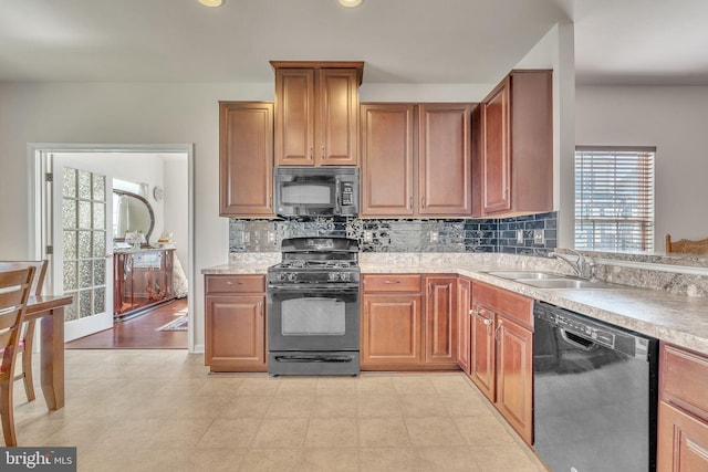 kitchen with backsplash, black appliances, and sink