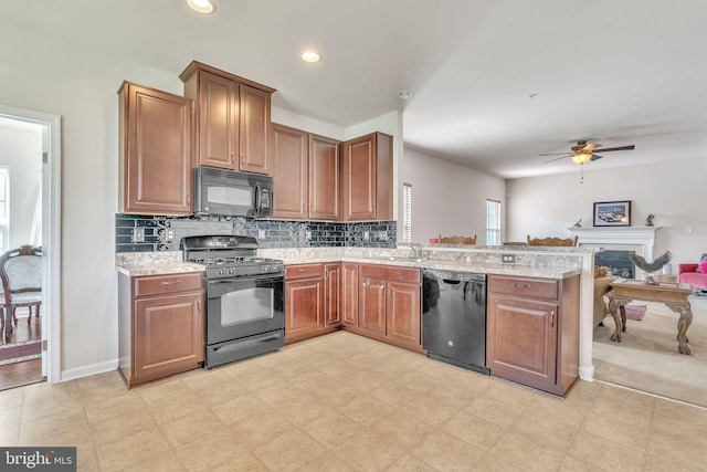 kitchen featuring light stone counters, tasteful backsplash, kitchen peninsula, black appliances, and ceiling fan