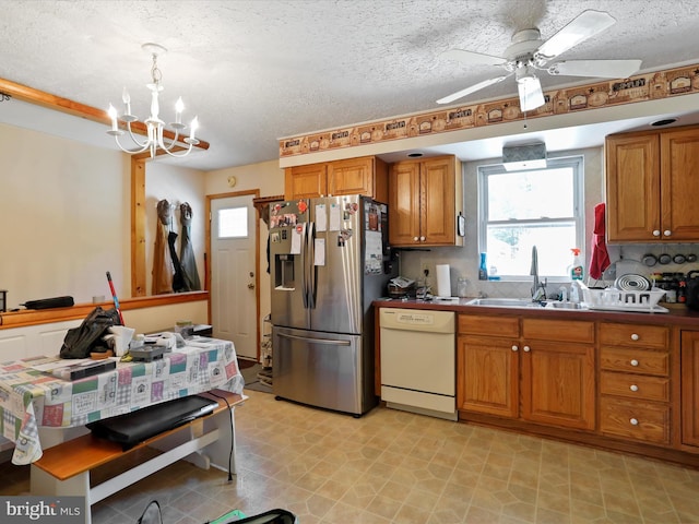 kitchen with sink, hanging light fixtures, tasteful backsplash, stainless steel fridge, and white dishwasher