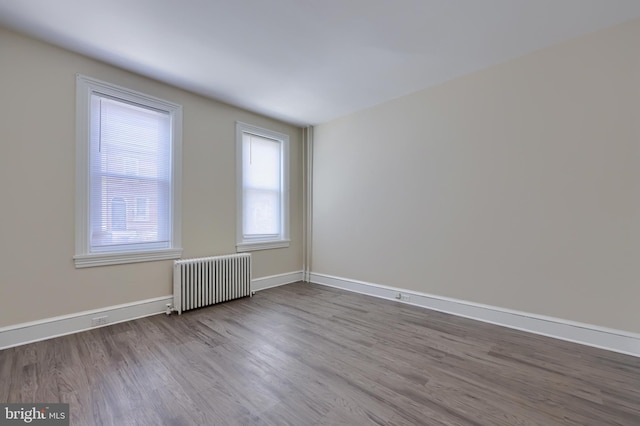 empty room with radiator and hardwood / wood-style floors